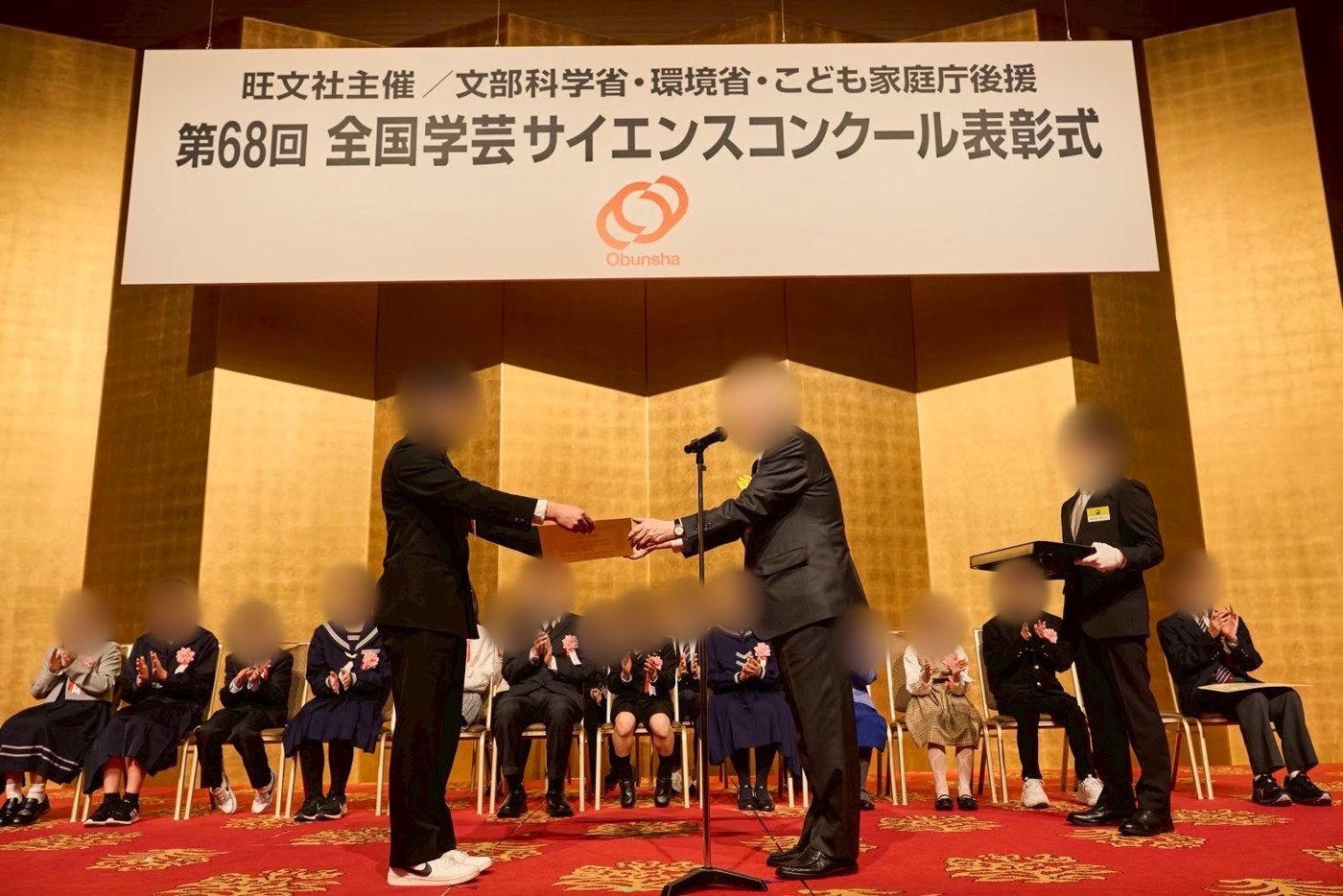 全国学芸サイエンスコンクール表彰式で賞状を受け取る様子（顔はぼかし加工）
